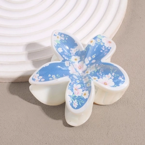 Detaillierte Draufsicht einer weißen Harz-Haarklammer mit blauem floralem Frangipani-Print