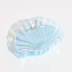 Detail of seashell hair claw clip with iridescent blue finish and pearlescent texture