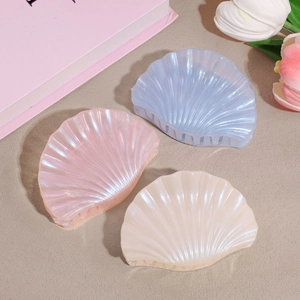 Three-piece colorful shell hair claws in pink, blue, and cream with pearlescent finish