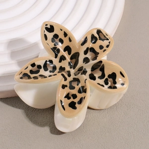 Détail d'une pince à cheveux en forme de fleur à motif léopard et base crème