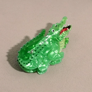 Vue détaillée d'une pince à cheveux crocodile avec texture marbre vert et design animalier