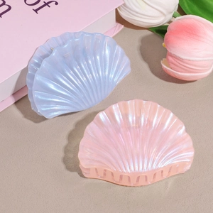 Close-up of shell-shaped hair claws in iridescent light blue and pink for elegant styling