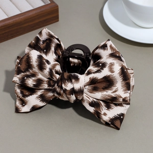 Detail view of large leopard print bow hair claw clip with rhinestones and metal spring