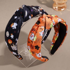 Détail de serre-têtes d'Halloween noués orange et noirs avec motifs citrouille et fantôme