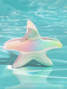 Dettaglio molletta a stella marina con finitura olografica in acqua di piscina