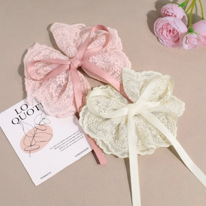 Detailed embroidery lace bow hair clips in pink and beige with wavy edges and ribbons