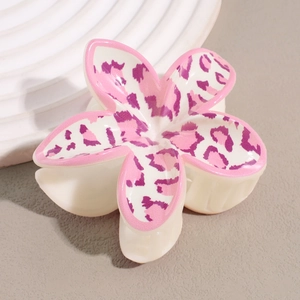 Détail macro de la pince à cheveux frangipanier avec motif léopard rose et design floral