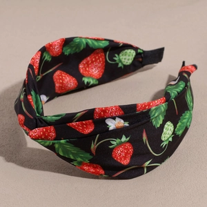 Detail of black wide knot headband featuring realistic red strawberry and flower patterns