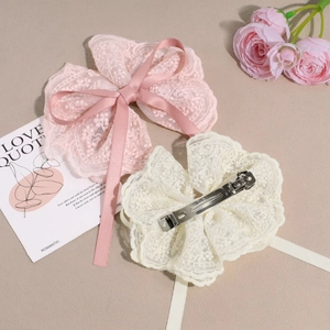 Elegant lace bow hair clips in pink and cream colors with floral embroidery and satin ribbons