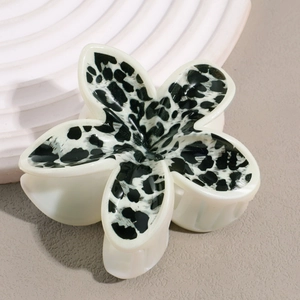 Détail de la pince à cheveux en forme de fleur avec imprimé léopard sur pétales blanc crème