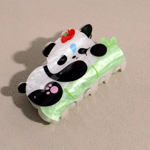 Détail d'une pince à cheveux panda tenant un bambou vert avec une finition nacrée