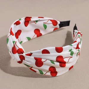 Detail of white fabric headband with red cherry print and twisted knot design