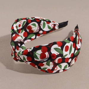 Detail of wide knotted fabric headband with cherry print and polka dot pattern