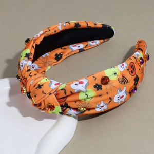 Détail du serre-tête large à nœud pour Halloween avec motifs citrouilles et strass colorés