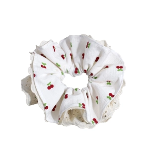 Sweet cherry print hair scrunchie with elegant lace trim and white fabric texture