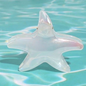 Pinza per capelli a stella marina iridescente con effetto laser su fondo d'acqua