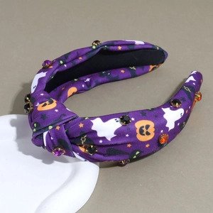 Détail d'un serre-tête noué d'Halloween avec motifs citrouilles fantômes et strass