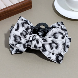 Detail of leopard print bow hair claw clip with rhinestones and black plastic grip