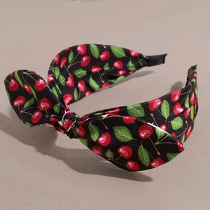 Detail shot of black headband with sweet cherry print and stereoscopic bow design