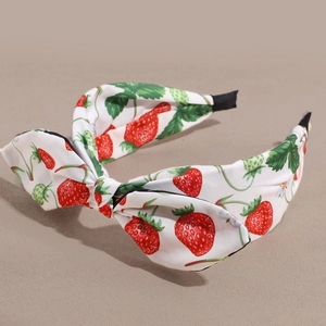 Close-up of strawberry print fabric headband with a stylish knotted bow detail