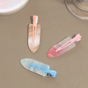 Three sweet marble resin duckbill hair clips in orange, pink, and blue with gold glitter