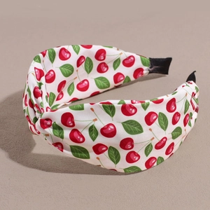 Detailed view of the red cherry print on a white wide knot headband with soft fabric texture