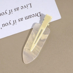 Detail of cream marbled acetate hair clip with subtle gold glitter and matte backing