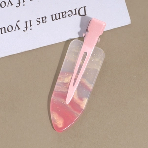 Detailed macro view of pink resin duckbill hair clip with glitter and marble texture