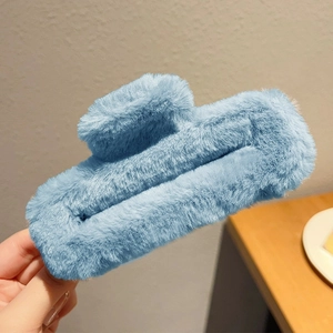 Gros plan d'une grande pince à cheveux en peluche bleu clair avec fausse fourrure