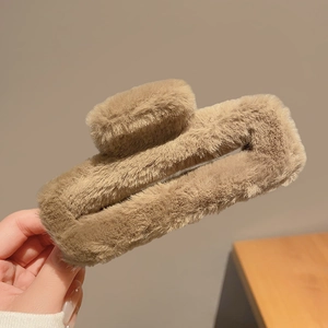 Gros plan d'une pince à cheveux en peluche marron clair en fausse fourrure douce et carrée