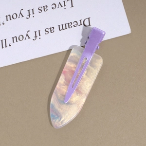 Detailed macro view of purple metal hair clip with iridescent marble resin texture