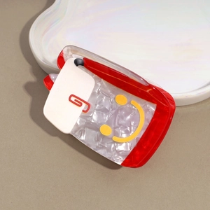 Dettaglio della molletta per capelli in acrilico rosso e marmo con smiley e motivo clip