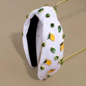 Detail of white knotted headband with green rhinestones and yellow lemon charms