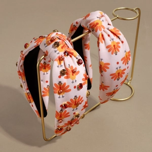 Pink knotted Thanksgiving headband featuring turkey patterns, red rhinestones, and pink pearls