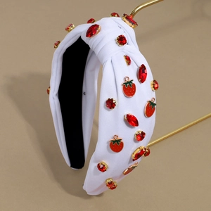 Detail of white fabric knotted headband featuring red rhinestones and strawberry charms