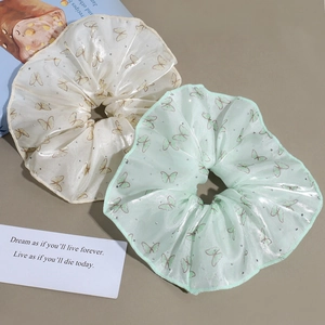 Set of two organza scrunchies with butterfly prints and rhinestones on aesthetic background