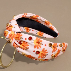 Close-up of Thanksgiving knotted headband with turkey print, rhinestones and pearls