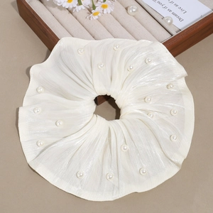Détail d'un chouchou géant blanc en tissu nacré orné de perles synthétiques élégantes