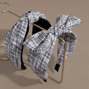 Elegant black and white tweed bow headband set with minimalist knot design on gold stand