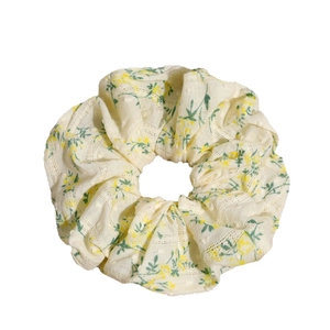 Floral scrunchie in creamy white fabric with yellow flowers and green leaf patterns