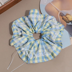 Checkered scrunchie with heart lace edge and bow on a stylish brown background