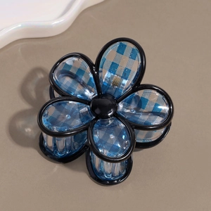 Detail of flower hair claw clip with blue and white plaid pattern and black acrylic edges