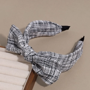 Detail of the black and white bow headband made of premium textured tweed fabric