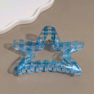 Detail view of star-shaped hair claw clip with blue checkerboard pattern and silver spring