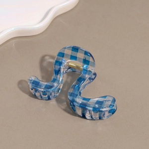 Macro view of blue plaid wavy claw clip with transparent texture and gold spring