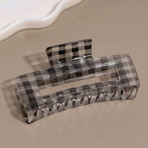 Detail of a large rectangular black and white checkerboard gingham hair claw clip