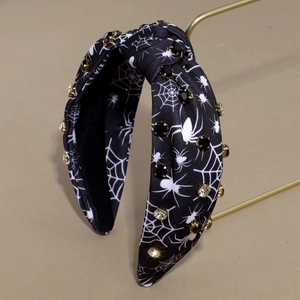 Dettaglio macro del cerchietto di Halloween con motivo ragnatela e strass scintillanti