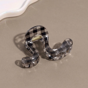 Detailed view of checkered acetate hair claw clip with sturdy metal spring mechanism