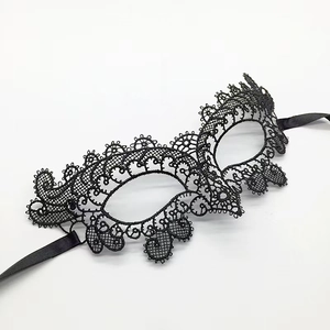 Detailed view of black lace fox mask with intricate embroidery and satin ribbons