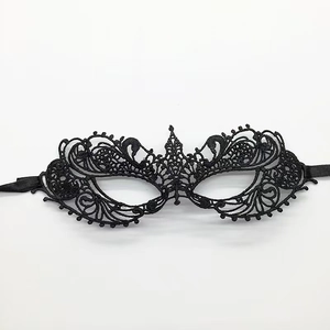 Close-up of black lace fox mask with intricate baroque embroidery and satin ribbons